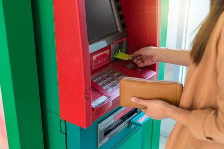 成人特写女拿着钱包通过ATM取款商业自动柜员机概念技术东南图片
