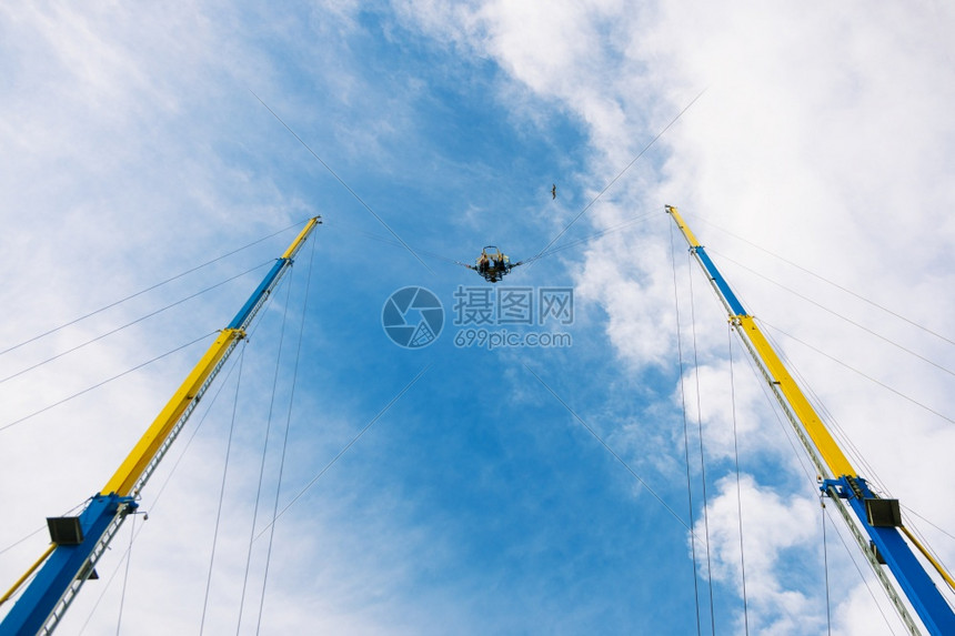 人们乘坐高空骑着危险的旋转木马在蓝天空背景夏日放松概念上乐趣一种圆形的图片