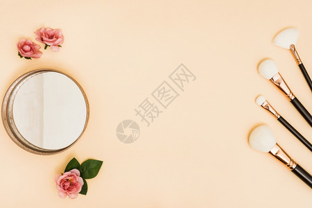 白化妆刷有紧凑火粉玫瑰彩色背景镜子美容师涂抹器图片
