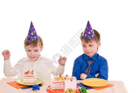 年轻的吃两个深思熟虑的男孩与一个蛋糕隔离在白色背景上盘子图片