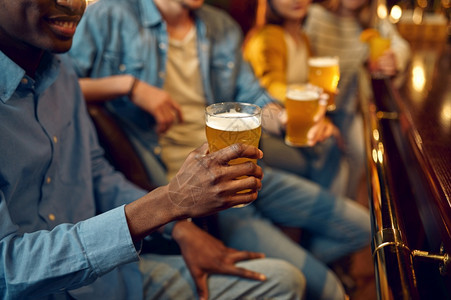 团体享受四个朋友在酒吧的柜台喝啤一群人在吧放松夜间生活方式友谊动庆祝四个朋友在酒吧的柜台喝啤女图片