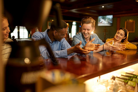 微笑的朋友在酒吧柜台休息在酒吧的人群中放松在酒吧的夜间生活方式友谊庆祝活动欢笑的朋友在酒吧柜台休闲餐厅吐司幸福图片