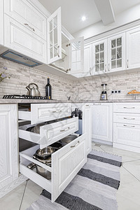 在豪华住宅的现代白色木制厨房内一些抽屉是开放的现代白色木制厨房内家具储物柜木制的图片