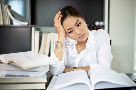 在家工作知识亚洲女商人和学生认真对待阅读书辛勤工作到头痛为止校对Portnoy笔记本电脑图片