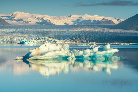 Jokulsarlon环礁湖带蓝色天空漂浮冰山岛雪海滩史卡法特图片