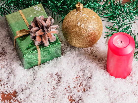 冬天快乐的包裹圣诞舞会红蜡烛和在雪中的礼物盒在树枝处的积雪中图片