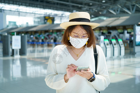 在机场戴口罩准备出行的女游客图片
