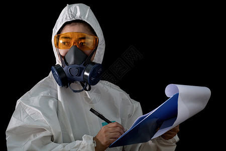 面罩干净的身着化学防护服和毒面具戴白底玻璃眼镜的妇女身穿安全西装的女科学家安全感染概念以及抽烟图片