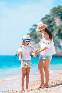 在沙滩上给女儿涂防晒的母亲图片