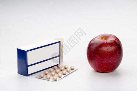 棕色的水泡颜药瓶红苹果丸盒和白色背景的红苹果箱图片