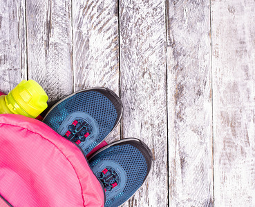 橡胶健身房粉红色背包和白木面水杯运动瓶中的蓝妇女对等运动鞋和白木表面水图片