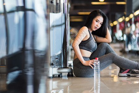 参加体操室内健身俱乐部和的亚洲妇女用一瓶水喝运动会种健身房成人图片