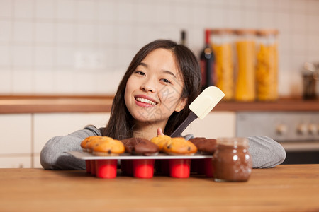 在厨房里微笑着的亚洲女人照片盘子里装满了松饼只要诱惑腰部图片