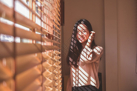 妇女在房间背景古年中站立在窗口上黑色的大厅年轻图片