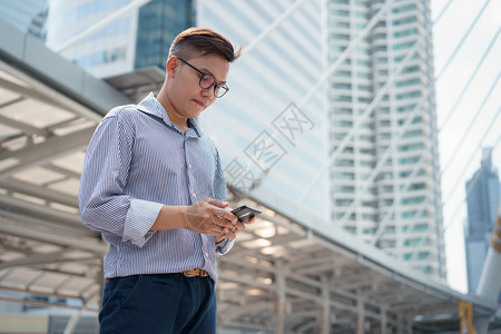 职业吸引人的自信年轻商人穿着微笑和看智能手机的西装他们笑着看智能手机校对Portnoy图片