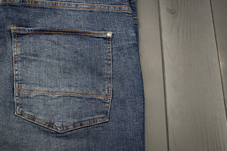 穿时尚后面一个被洗过的蓝色牛仔裤口袋上面有在灰木背景上缝金针向量图片