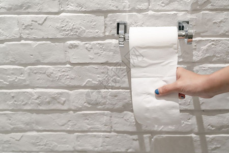 白种人女用手从洗间组织卷里拉一张白纸干净的一种图片
