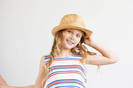 时尚金发女郎吸引人的可爱小女孩用草帽顶着白色背景的帽子快乐孩图片