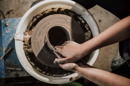 手工业人们在陶器车轮上工作的匠手掌选择焦点轮子图片