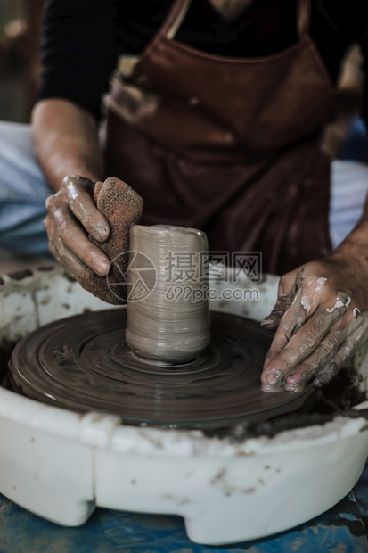 肮脏的雕塑家在职陶器车轮上工作的匠手掌选择焦点图片