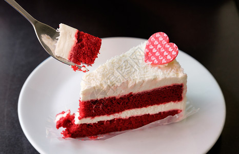 红天鹅绒蛋糕和白奶油用勺子放在木制桌上经典的美味烘烤图片