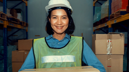 头盔亚洲年轻女仓库工人在中微笑的肖像物流供应链和仓库业务概念亚洲年轻女仓库工人在中微笑的肖像oopicapi年轻的图片