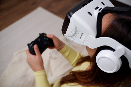 创新在客厅装着虚拟现实眼镜玩电游戏的年轻女青风镜人们图片