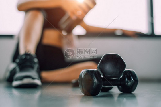 技术哑铃与运动女生活方式锻炼在健身房打破运动训练后放松与蛋白质奶昔瓶背景健康生活方式美运动员肌肉的特写嬉戏饮食图片