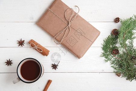 新年背景肉桂火化恒星fir树枝aCup热巧克力和一个盒装礼物的子白色木制背景温暖的丝带新图片