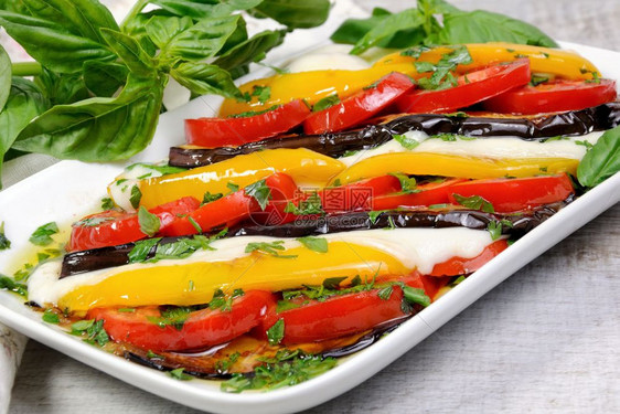 堆叠的帕尔马干酪含西红柿黄胡椒和切片莫扎里拉的烤茄子低卡路里图片