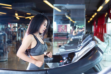 女参加体育室内和卫生俱乐部运动场跑步训练的亚洲妇女从事锻练培训的亚洲妇女耳机运动型图片