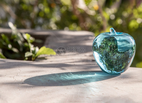 玻璃晶蓝苹果和自然绿色背景上的反射面复制空间选择焦点有的美丽清除澈图片