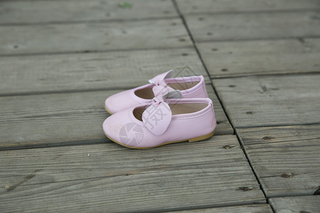 蓝色的服装2019年7月4日拉脱维亚Cesis市的粉红婴儿鞋摊在木制地板上的图片