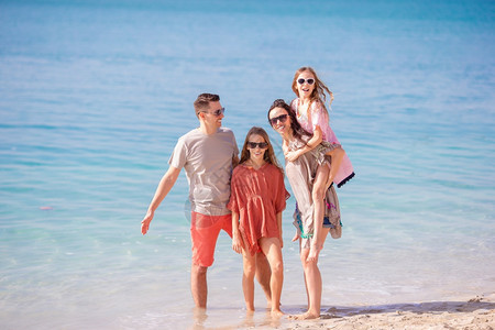 四口在海滩上的家庭度假年轻家庭有很多乐趣父母夏天孩子图片