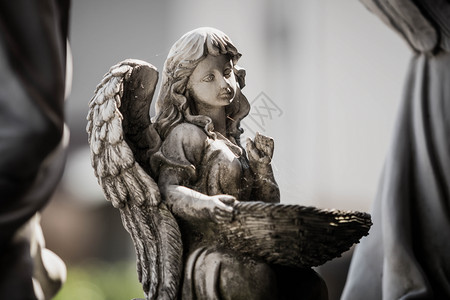 经典的希腊语历史花园里一个拿着篮子的天使雕像图片素材