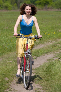 快乐的女孩骑自行车去草地上女积极的外部图片