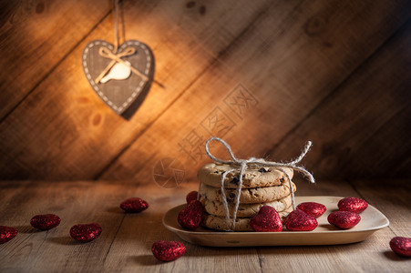 情人节背景有传统的美国饼干巧克力薯片和心形糖果在黑暗的生锈木制餐桌边情人节背景饼干和心形糖果还有饼干和心形糖果装饰快乐木制图片