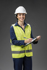 建造使用剪贴板的女工程师肖像穿快乐的图片