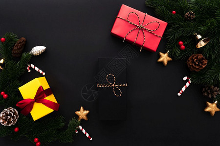 光滑漂亮的宗教圣诞礼品盒和松树黑色背景有X马装饰品图片