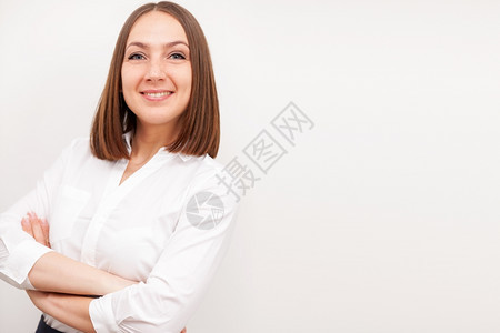 成功的黑发女商人肖像她用交叉手在孤立的白色背景上公司微笑时尚图片