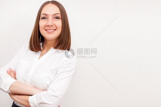 成功的黑发女商人肖像她用交叉手在孤立的白色背景上公司微笑时尚图片
