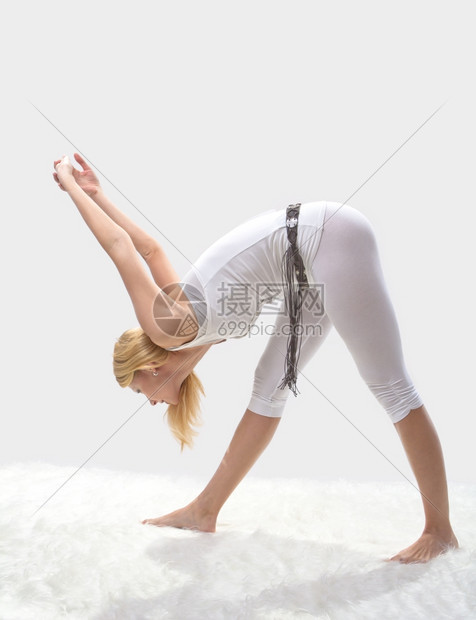 年轻漂亮女孩在专业上从事瑜伽工作祈祷爱好放松图片