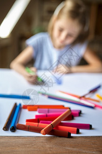 人们刷子乐趣小女孩在桌子上用记号笔画在工作室里的孩子在艺术学校上课年轻画家愉快的爱好乐童年创意发展用记号笔画的小女孩在工作室里的图片