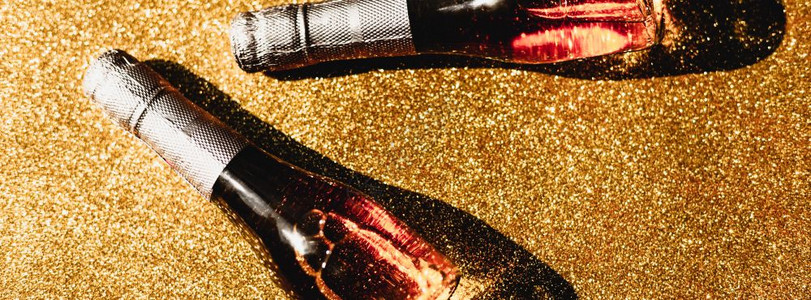 闪发光黑暗的作品圣诞或新年的配制盛满玫瑰香槟的瓶子在金光闪亮背景上以黑暗阴影为顶端风景庆祝平坦的世俗派对创意概念图片