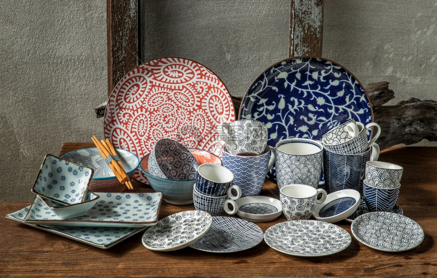 陶瓷制品热情不同的陶瓷板碗和木制桌上的杯子陶瓷餐具美丽安排选择焦点材料图片