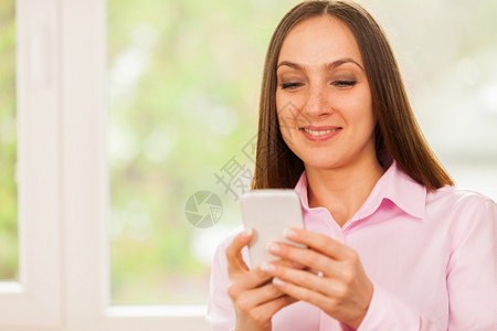 笑脸女商人在她的手机上打短信肖像互联网图片