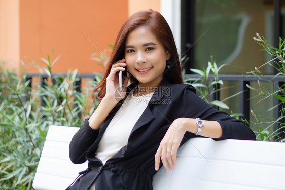 自信的肖像随意使用电话在移动上进行手机接听和发短信的女商人图片