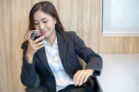 使用电话在移动上进行手机接听和发短信的女商人男行政员图片