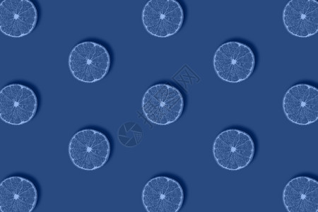 单色调蓝背景的鲜柠檬切片水果图案在蓝色背景的平原上被孤立新鲜柑橘碎面板顶层视图流行艺术设计创造夏季概念MinimimalStyl图片