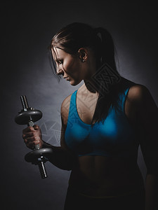 肖像身穿运动服的年轻女子外出大腿工作室拍摄黑暗背景吸引人的运动员图片